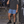 Haze Blue 2-in-1 running shorts worn with a washed grey tee, man leaning on a brick wall by the stairs