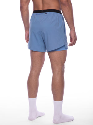 Haze Blue running shorts in a back three-quarter view on a model, inner layer under the split hem