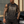 A tattooed model leans on a grey car in the washed black muscle shirt, worn with black cargo jeans