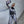 Person in a futuristic, form-fitting suit taking a selfie against a plain wall.