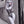 Person in a futuristic bodysuit leaning against a wall.