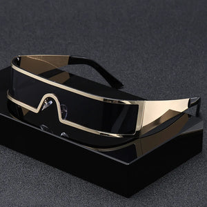 Gold-framed sunglasses on a black stand against a dark background