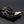 Gold-framed sunglasses on a black stand with a dark background
