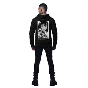 Person wearing a black hoodie with a graphic design, standing in an urban alleyway with graffiti.