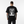Person wearing a black t-shirt with 'Cyber Techwear' design on the back, standing against a white background.