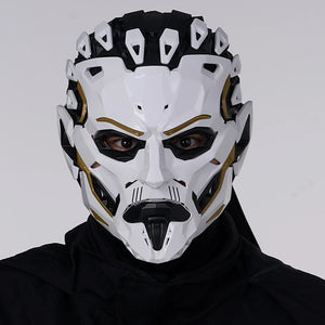 Person wearing a white and black mask with gold accents on a gray background
