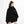 Person wearing a black poncho with a small white logo on a white background