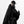 Person wearing a black outfit with a cape and mask on a white background