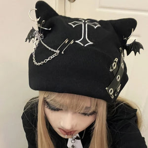 Black cat ear hat with decorative elements worn by a person against a neutral background