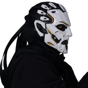 Person wearing a futuristic white and black helmet with gold accents on a plain background