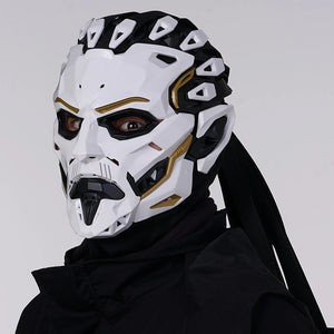 Person wearing a futuristic white and black mask with gold accents on a plain background