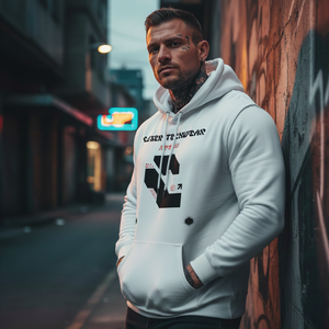 Man wearing a white hoodie leaning against a graffiti-covered wall on a street.
