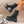 Black platform boots with buckles worn by a person, against a mosaic tile wall background.