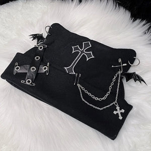 Black fabric with metal accessories including chains and crosses on a white fluffy surface