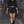 Model walking a night street in the Black A Line Tennis Skort and black crop top, white piped slit in view