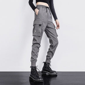 Gray snap pocket joggers in three-quarter view, oversized loose fit through the thigh, ribbed cuffs over boots