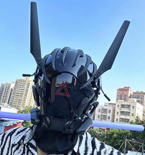 Black techwear mask with tall antenna blades and a red triangle indicator