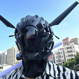 Black techwear mask with tall antenna blades and a red triangle indicator