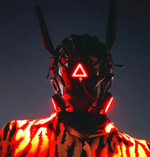 Black techwear mask with tall antenna blades and a red triangle indicator