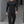 Model walking outdoors in the black long sleeve compression shirt with black cargo pants, front view