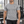 Mand der går rundt i et fitnesscenter i den meleret grå kompressionstrøje, set forfra med raglanærmer og rund hals