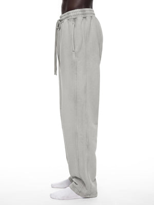 Side view of the Light Gray barrel leg sweatpants on a model, showing the curved leg and long drawstring