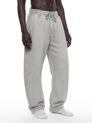 Light Gray sweatpants in a three-quarter front view on a model, front pleat at the knee and slash pocket
