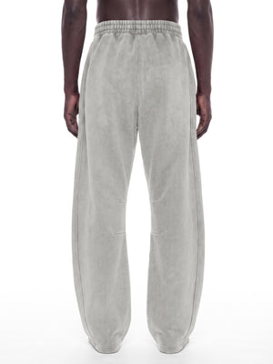 Back view of the Light Gray baggy sweatpants on a model, elastic waist and full length loose legs