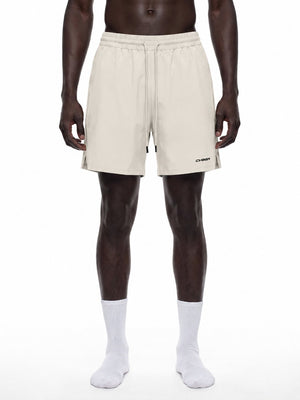 Man wearing the Baggy Khaki Lined Workout Shorts, front view with drawstring, side slits and CYBER logo