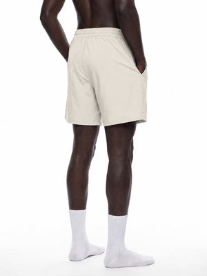 Man in the Pale Khaki workout shorts in a back three-quarter view, hand in the side pocket