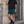 Man leaning against a stone wall in the Deep Teal lined gym shorts and a black tee, front view