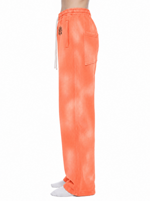 Profile view of the Orange sweatpants on a model, showing the loose fit and the full length wide leg