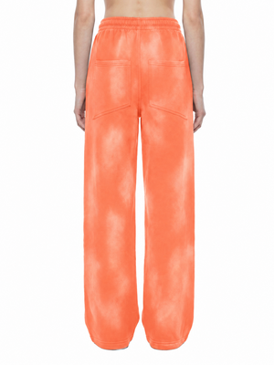 Back view of the Orange baggy sweatpants on a model, showing both back pockets and the elastic waistband