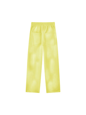 Yellow baggy sweatpants seen from the back on a plain background, elastic waist and two patch pockets