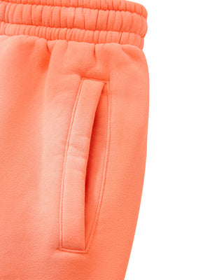 Detail of the side slash pocket on the Orange sweatpants, with the elastic waistband above it