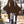 Dark brown gothic mini dress with long pointed sleeves, front walking view with black platform boots