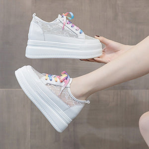 Best White Platform Sneakers held in hand, rainbow laces and thick white platform sole