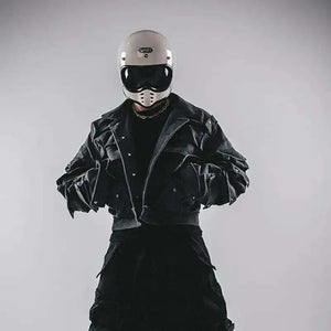 Person wearing a black jacket and helmet on a gray background