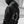 Back of the Black Hooded Techwear Windbreaker: large circular print, hood down and a zip pocket on the sleeve