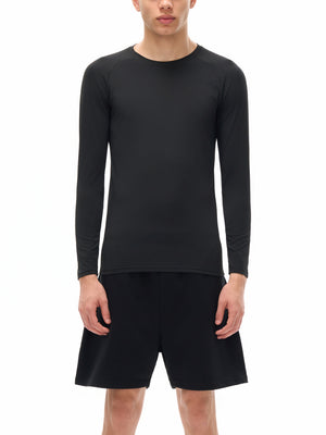 Model wearing the black long sleeve compression shirt with black shorts, plain front view on white