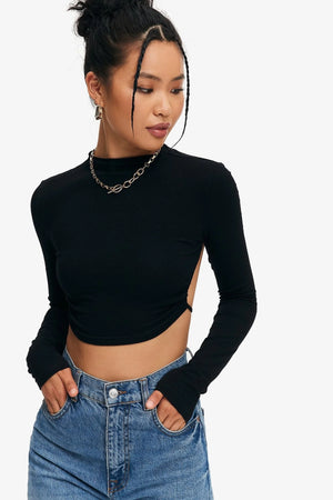 Black long sleeve crop top, front view of the mock neck and the curved cropped hem above high-waisted blue jeans