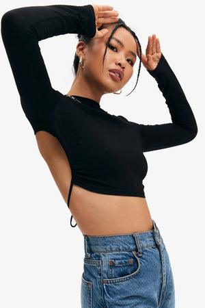 Black Long Sleeve Crop Top, model with an arm raised above the head, open back and the tie at the lower back