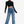 Full length view of the black crop top with wide-leg blue jeans and black heels, long sleeves and mock neck