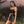 Model in the black Y2K skirt set outdoors, spaghetti-strap crop top and fitted mini skirt with white contrast piping