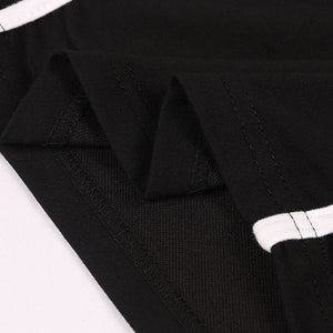 Close-up of the black cotton fabric and the white piped seam on the crop top, shown folded flat