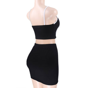 Side view on a mannequin of the black crop top and mini skirt set, white piping along the top neckline and straps