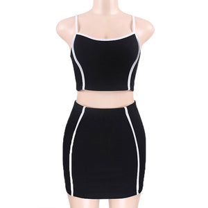 Front view on a mannequin of the black skirt set, white piping down the crop top and along the skirt side seams