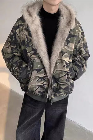 Oversized camojakke med langhåret hættefor, set forfra, hænderne i sidelommerne og vide jeans