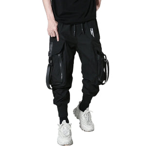 Person wearing black cargo pants with multiple pockets on a white background