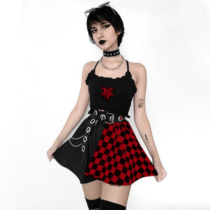 Modelo usando a mini saia Goth xadrez vermelha e preta com cropped preto de alças finas, cinto com corrente e meias até o joelho